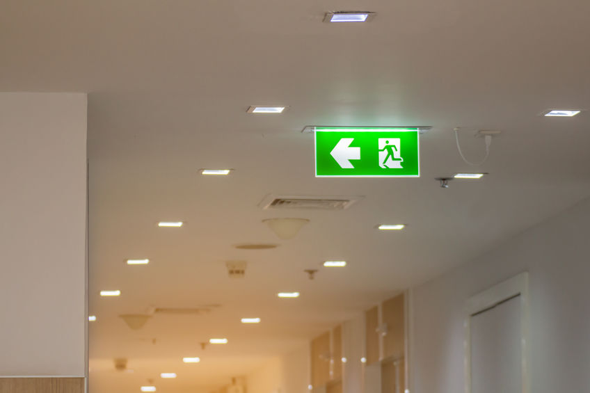 green emergency exit sign in hospital showing the way to escape